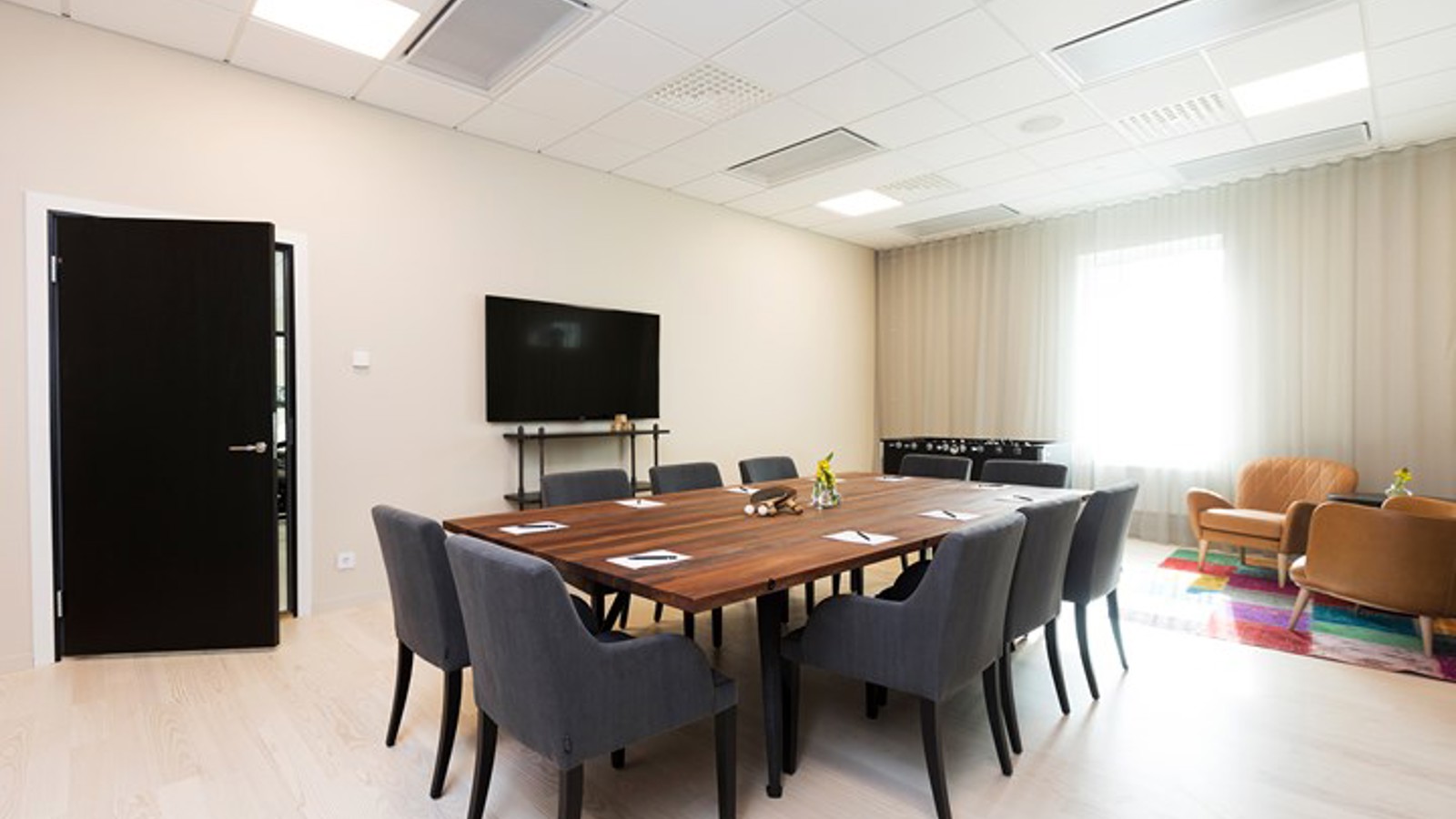 Conference room with board seating, wooden table and light walls