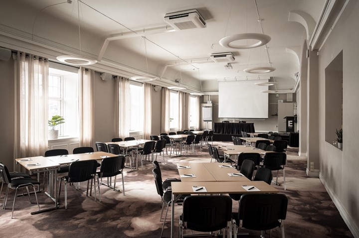 Konferensrum med ö-sittning, stora fönster och projektor