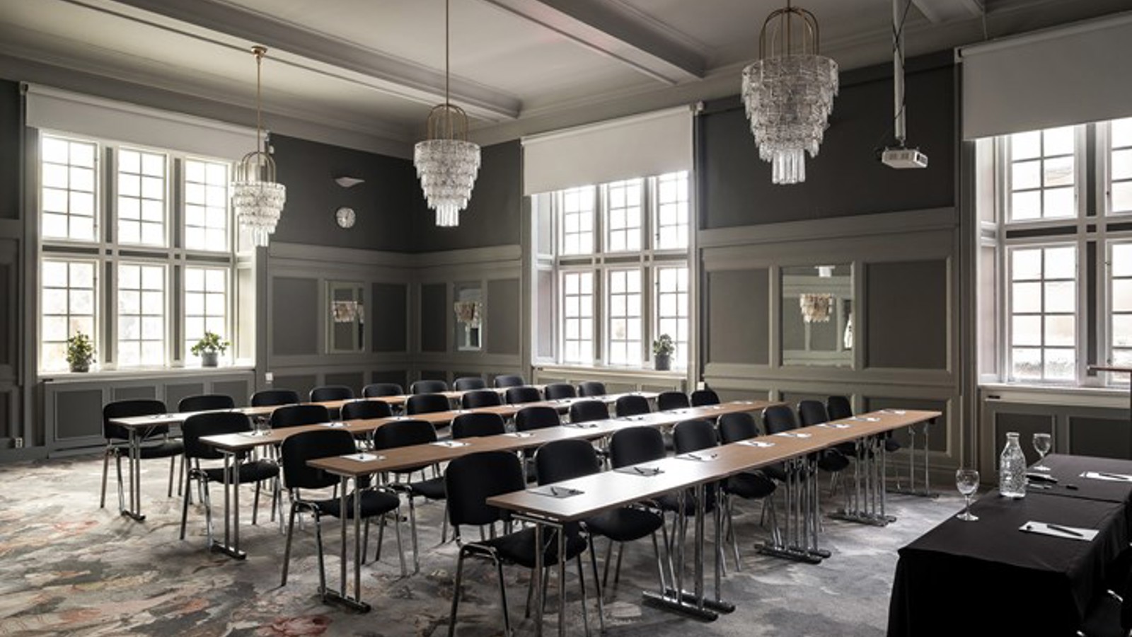 Conference room with school seating, large windows and crystal chandeliers