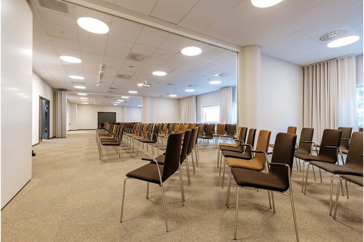 Konferensrum med biosittning, bruna stolar och stora fönster