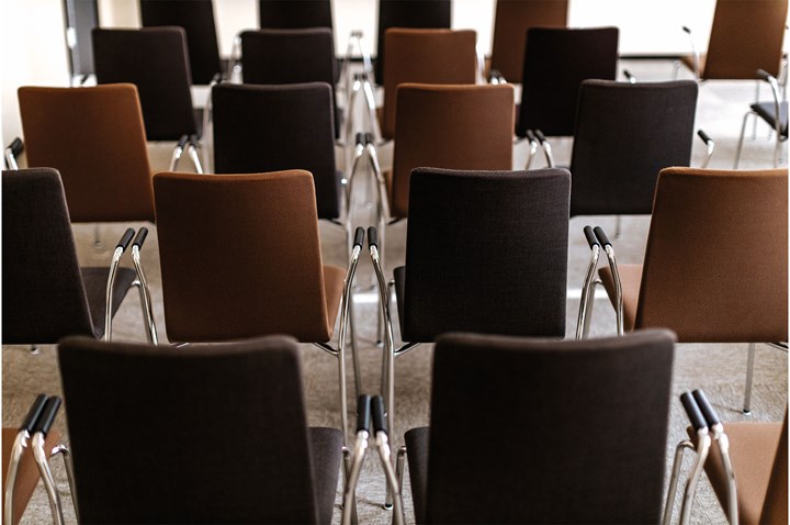 Närbild på uppradade stolar i olika nyanser av brunt