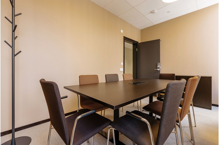 Konferensrum med styrelsesittning i bruna färgtoner