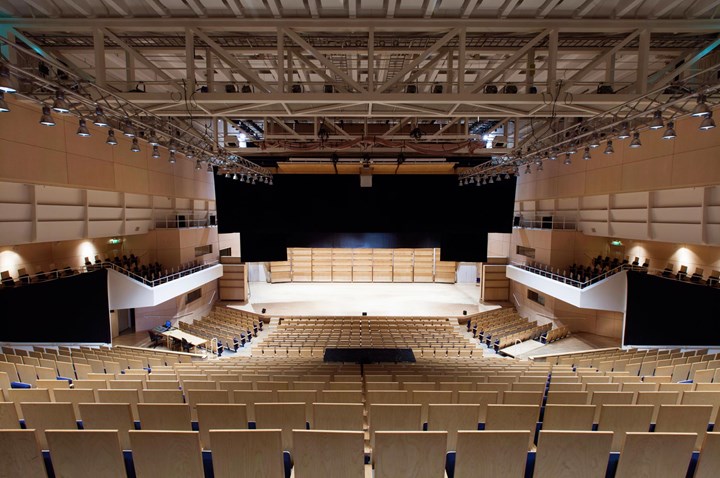 Large hall with stage, rows of chairs and spotlights in the ceiling