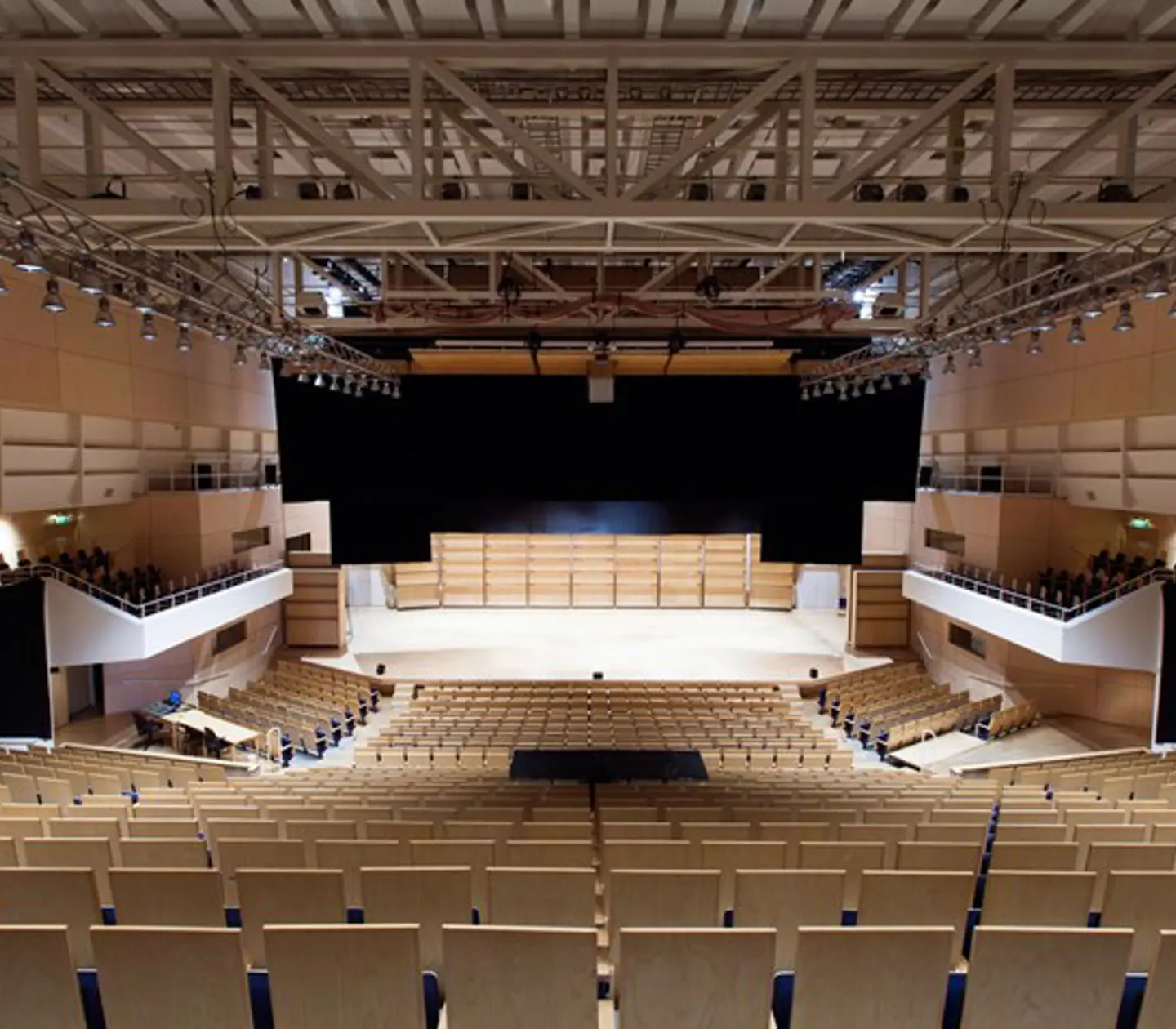 Large hall with stage, rows of chairs and spotlights in the ceiling