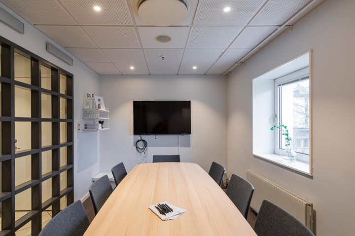 Conference room with board seating, wooden table, TV screen and window