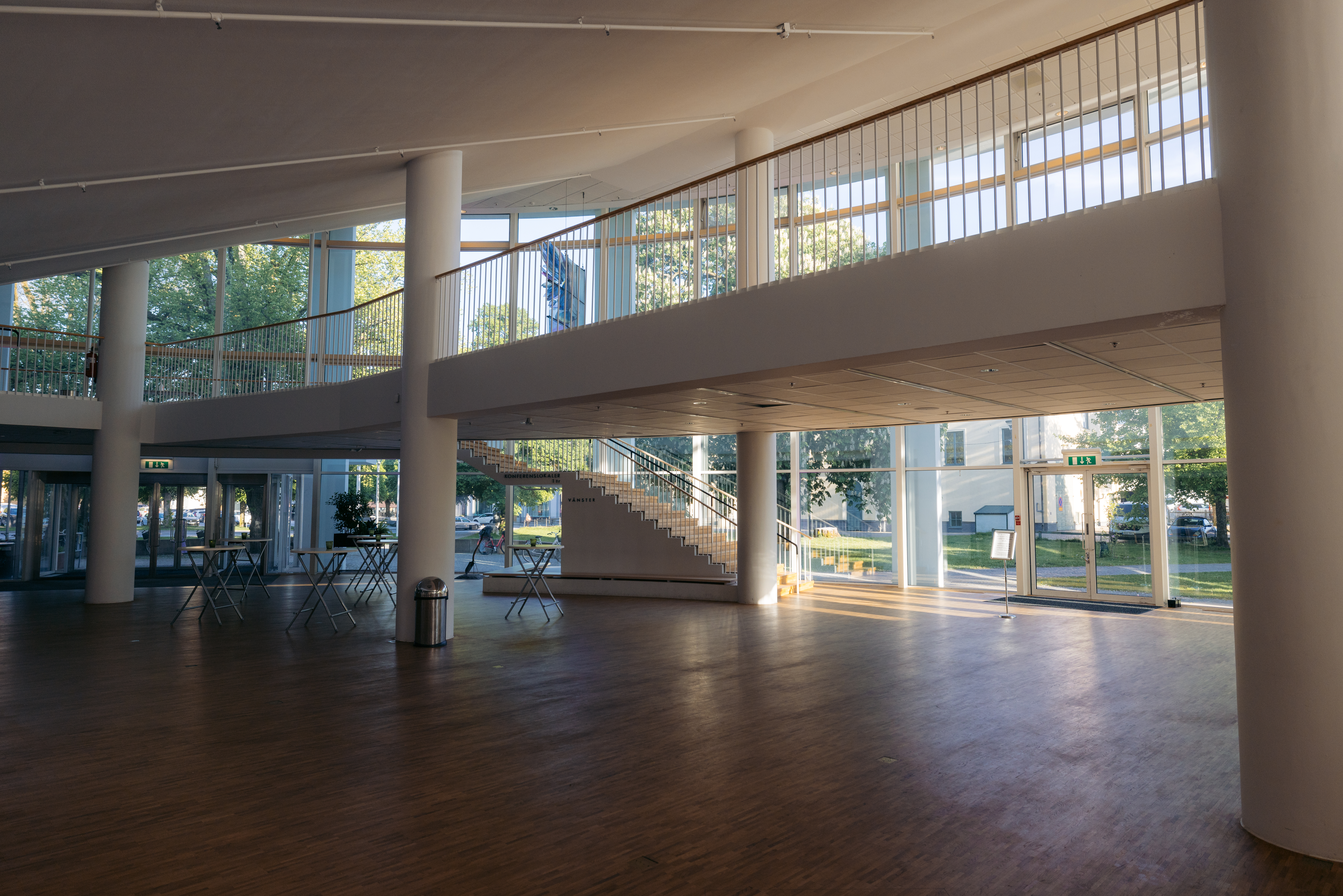 Large open entrance with white pillars, staircase and large windows