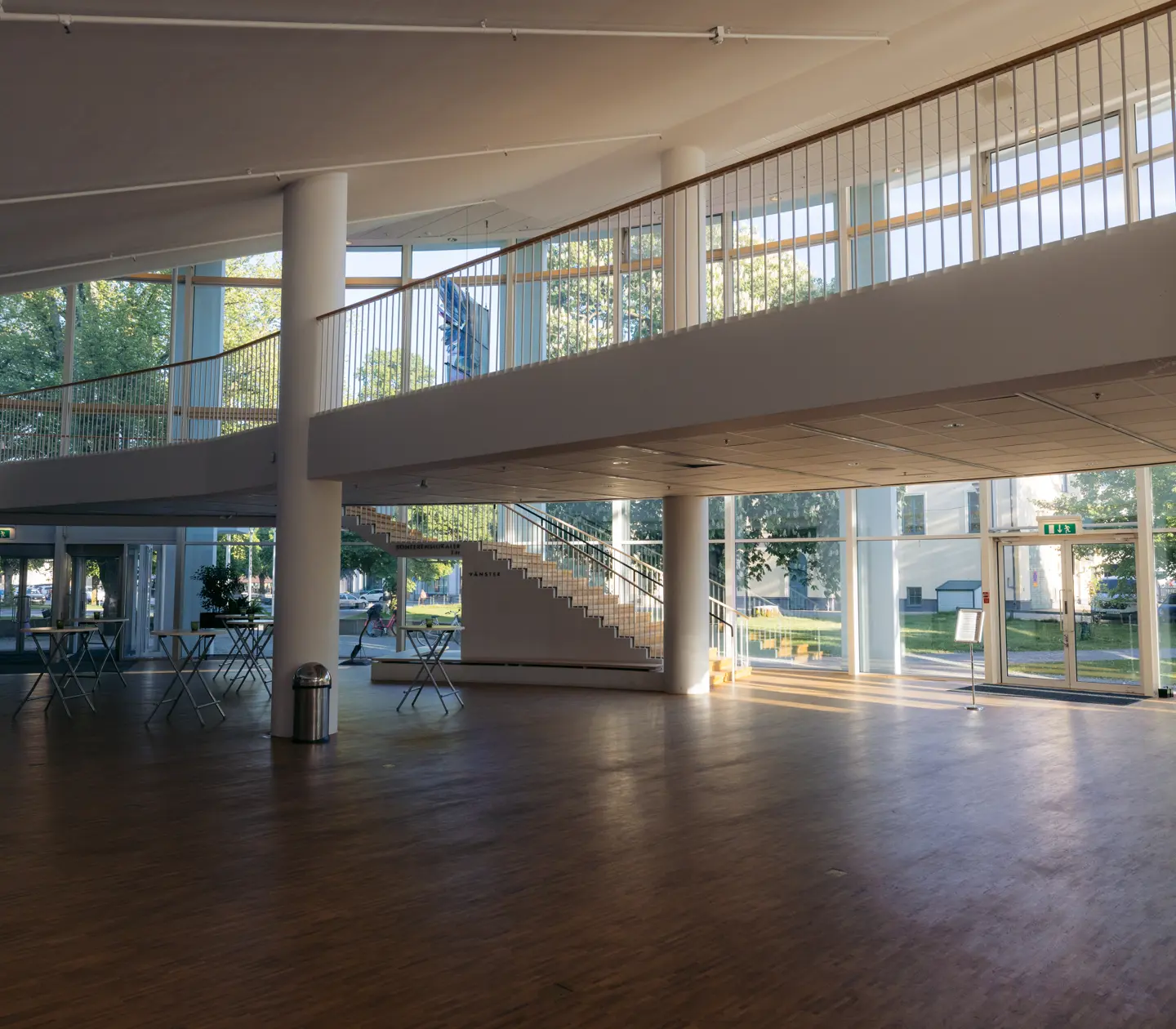 Large open entrance with white pillars, staircase and large windows