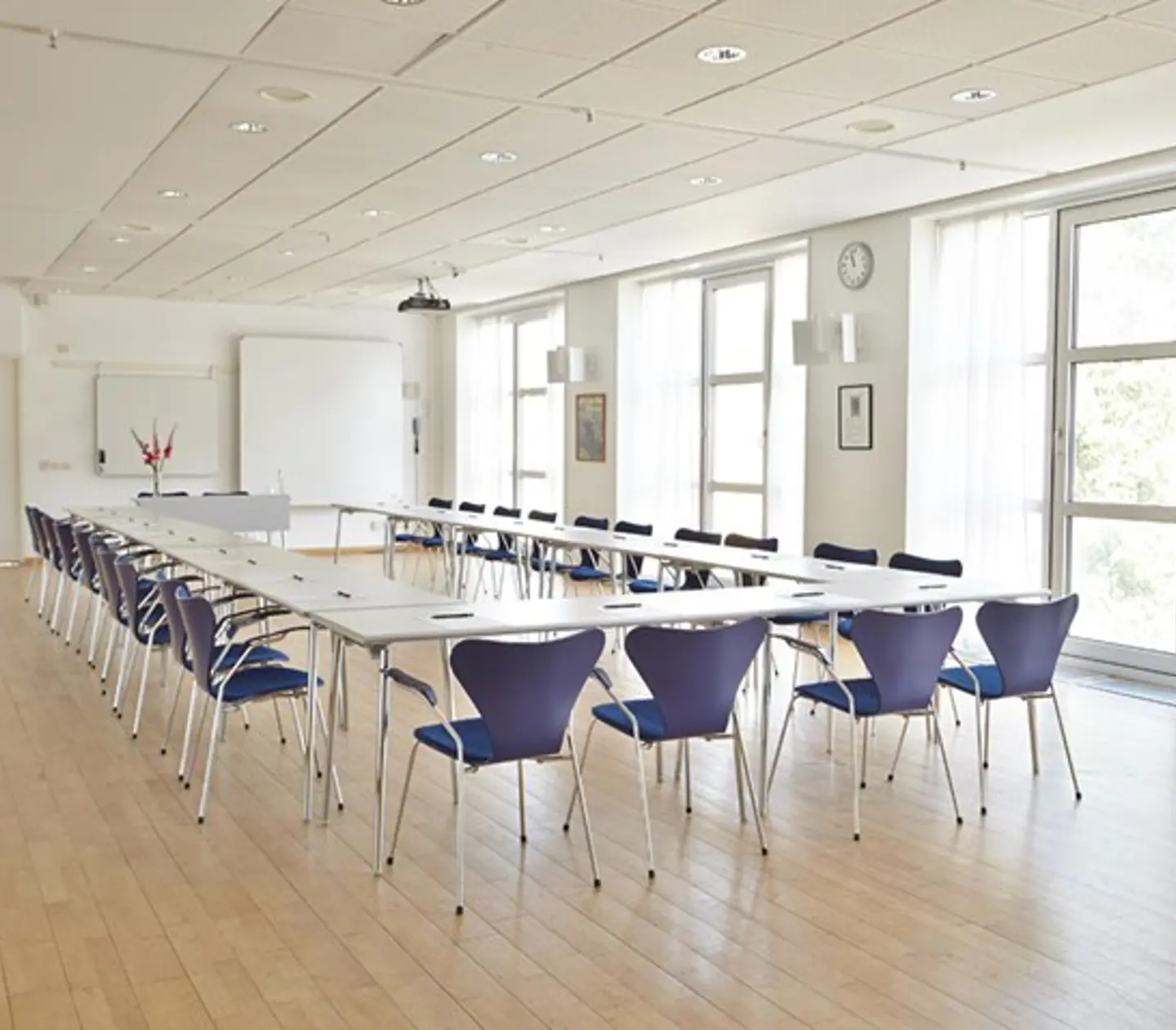Bright conference room with U-shaped seating and large windows