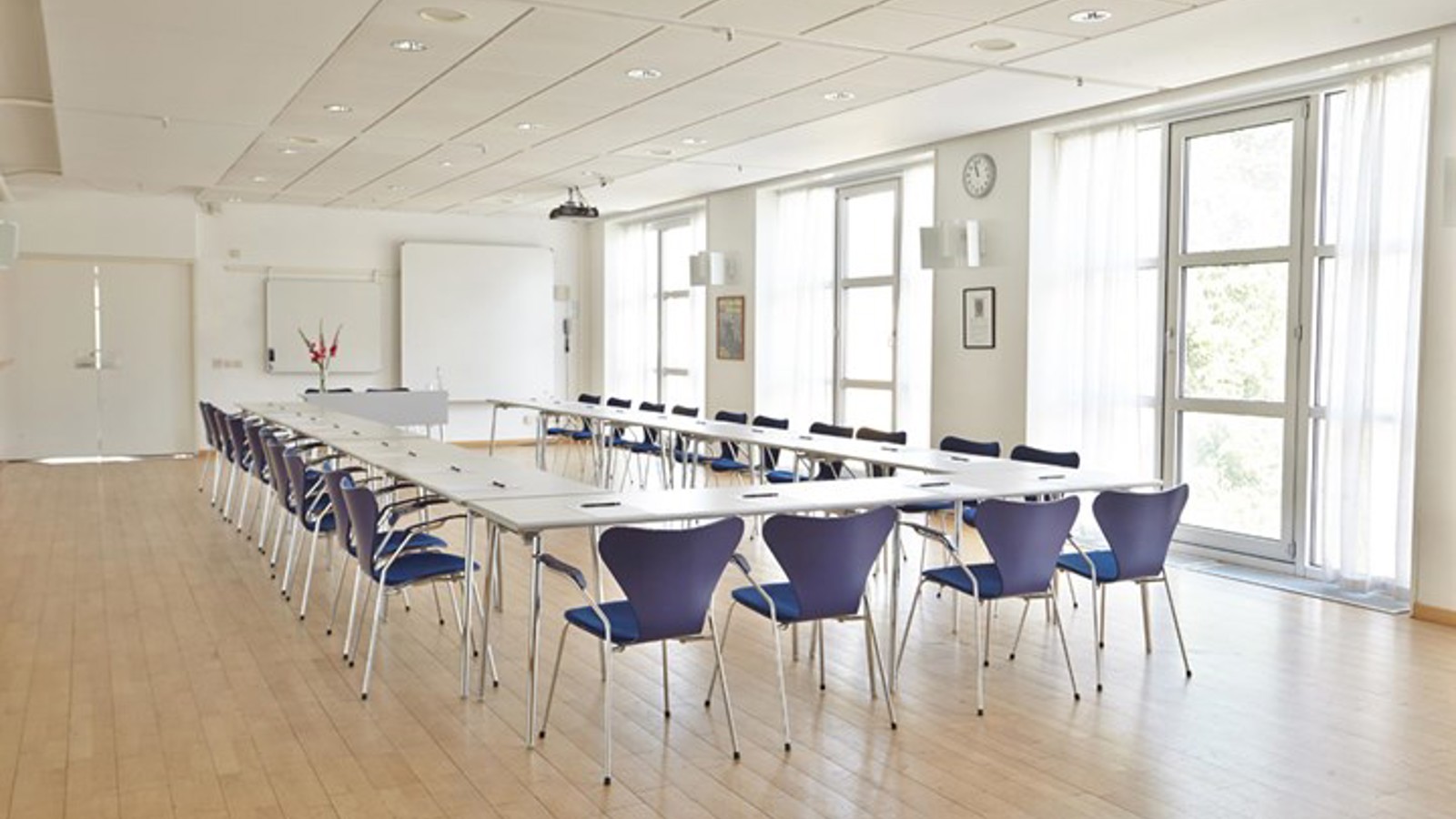 Bright conference room with U-shaped seating and large windows