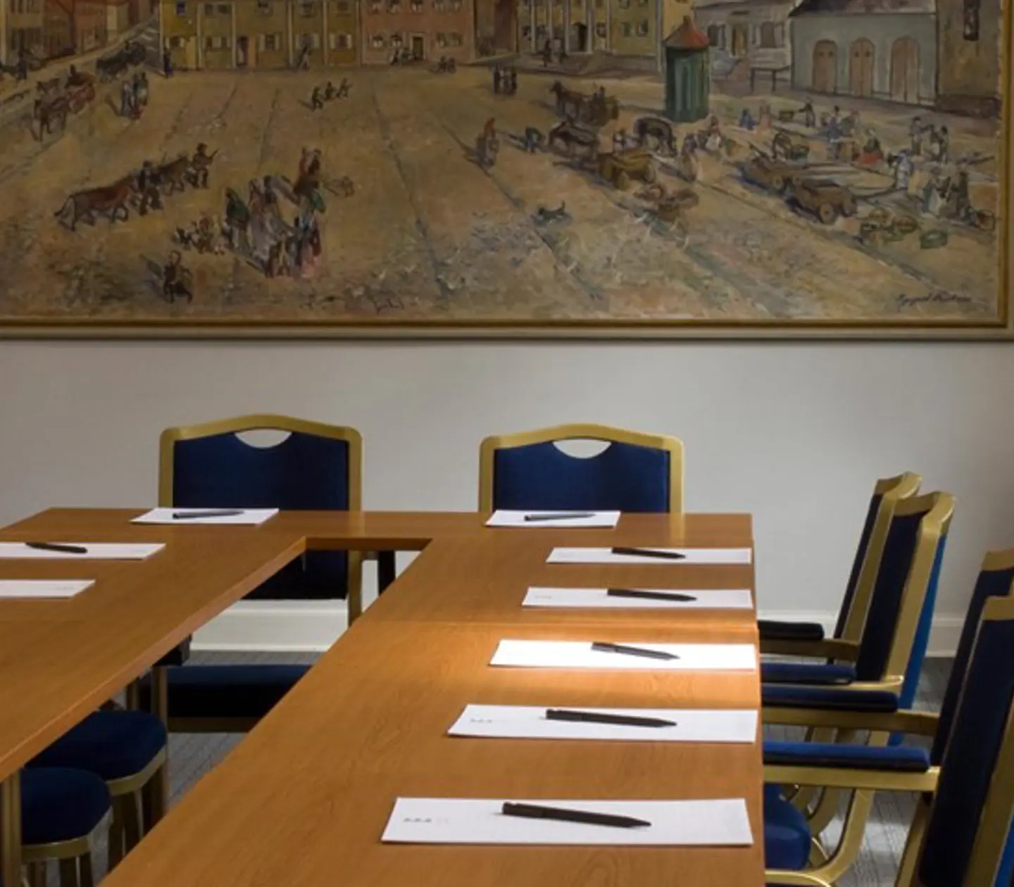 Konferensrum med u-sittning, träbord och stor tavla