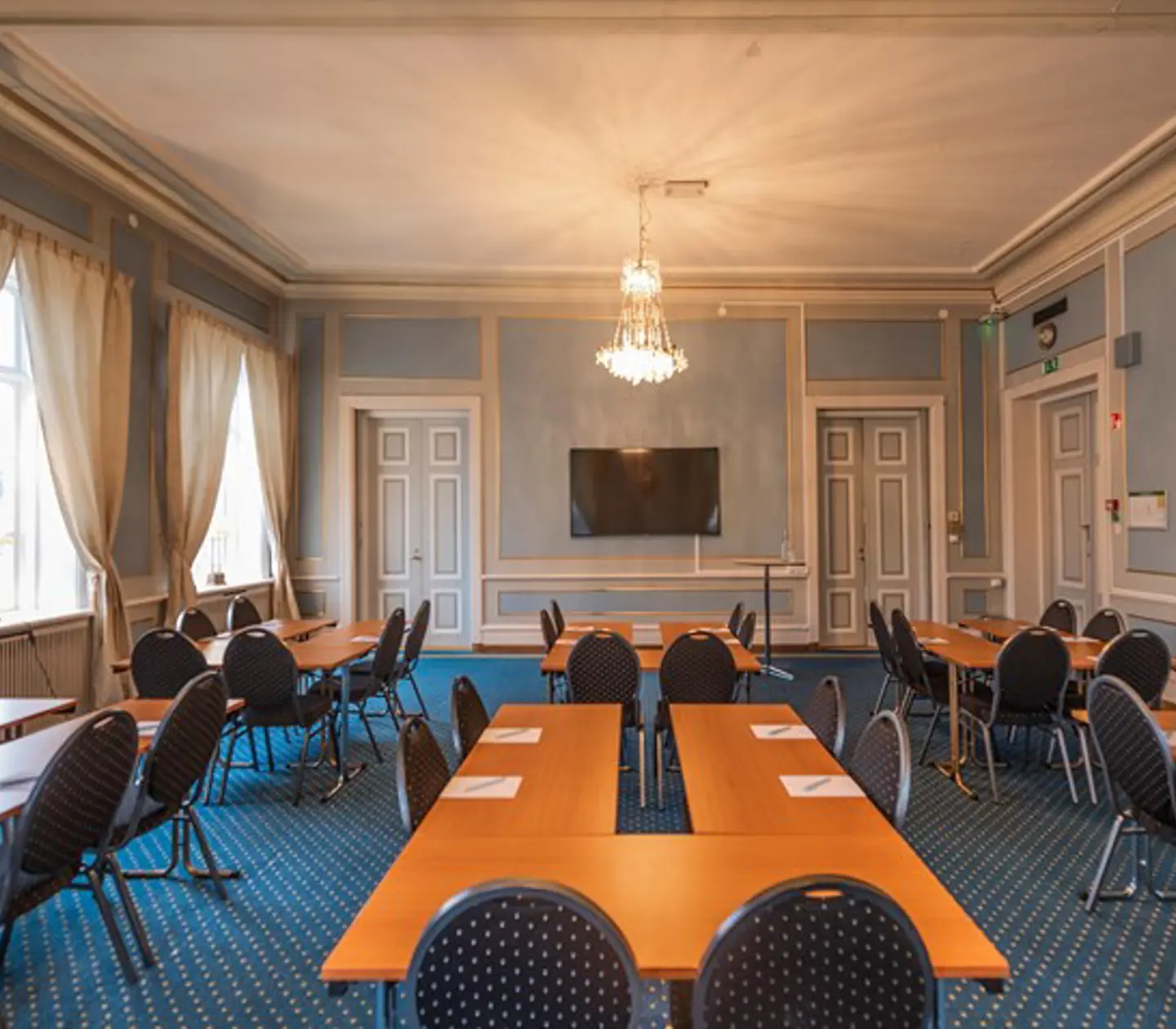 Blått konferensrum med ö-sittning, stora fönster och träbord