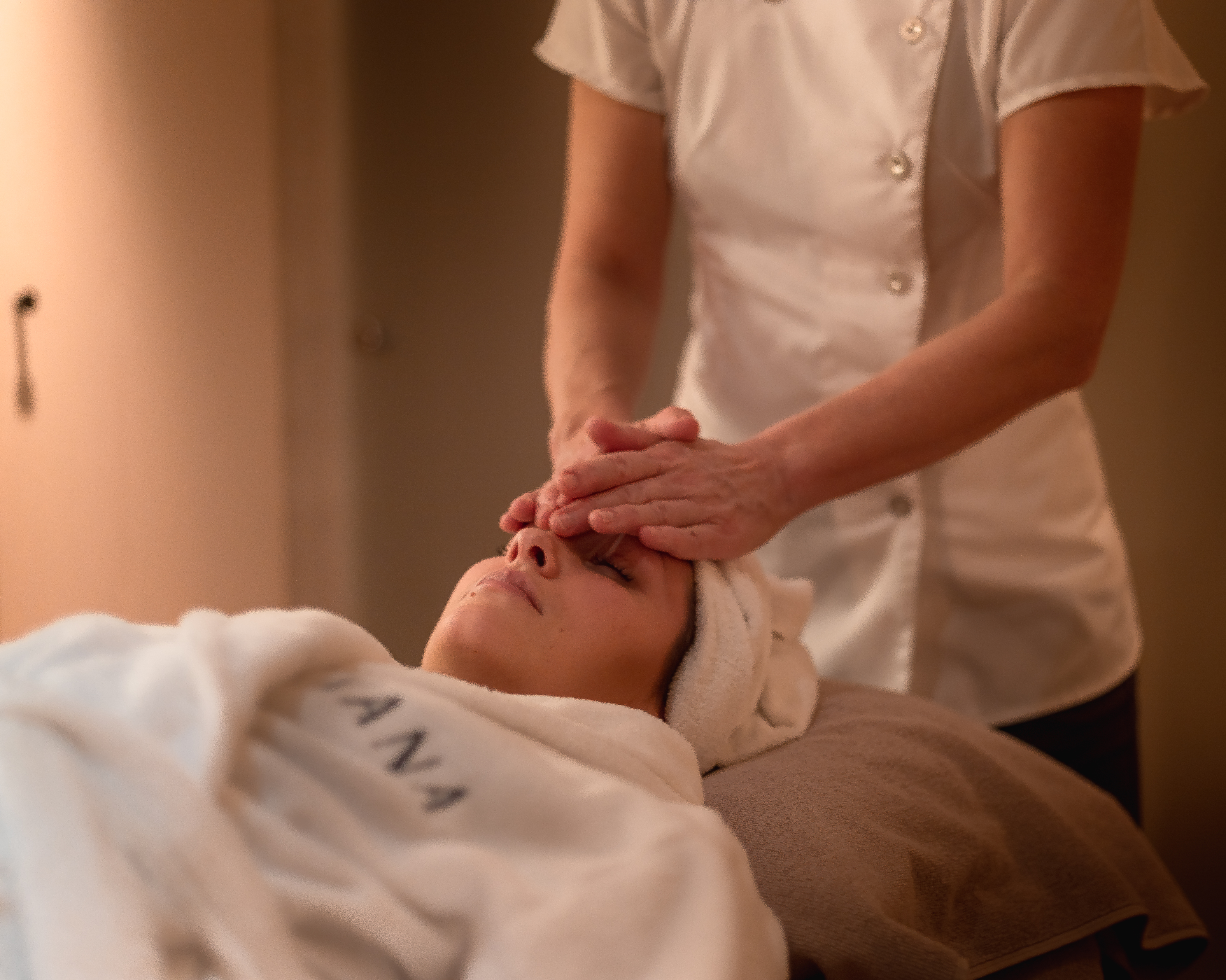 Woman in bathrobe getting massage
