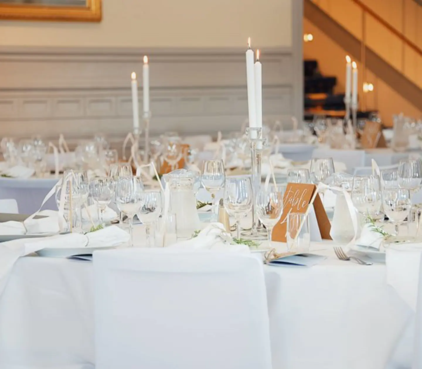 Restaurangbord med vita dukar och finservis