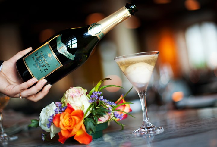 Waiter pours champagne into glass