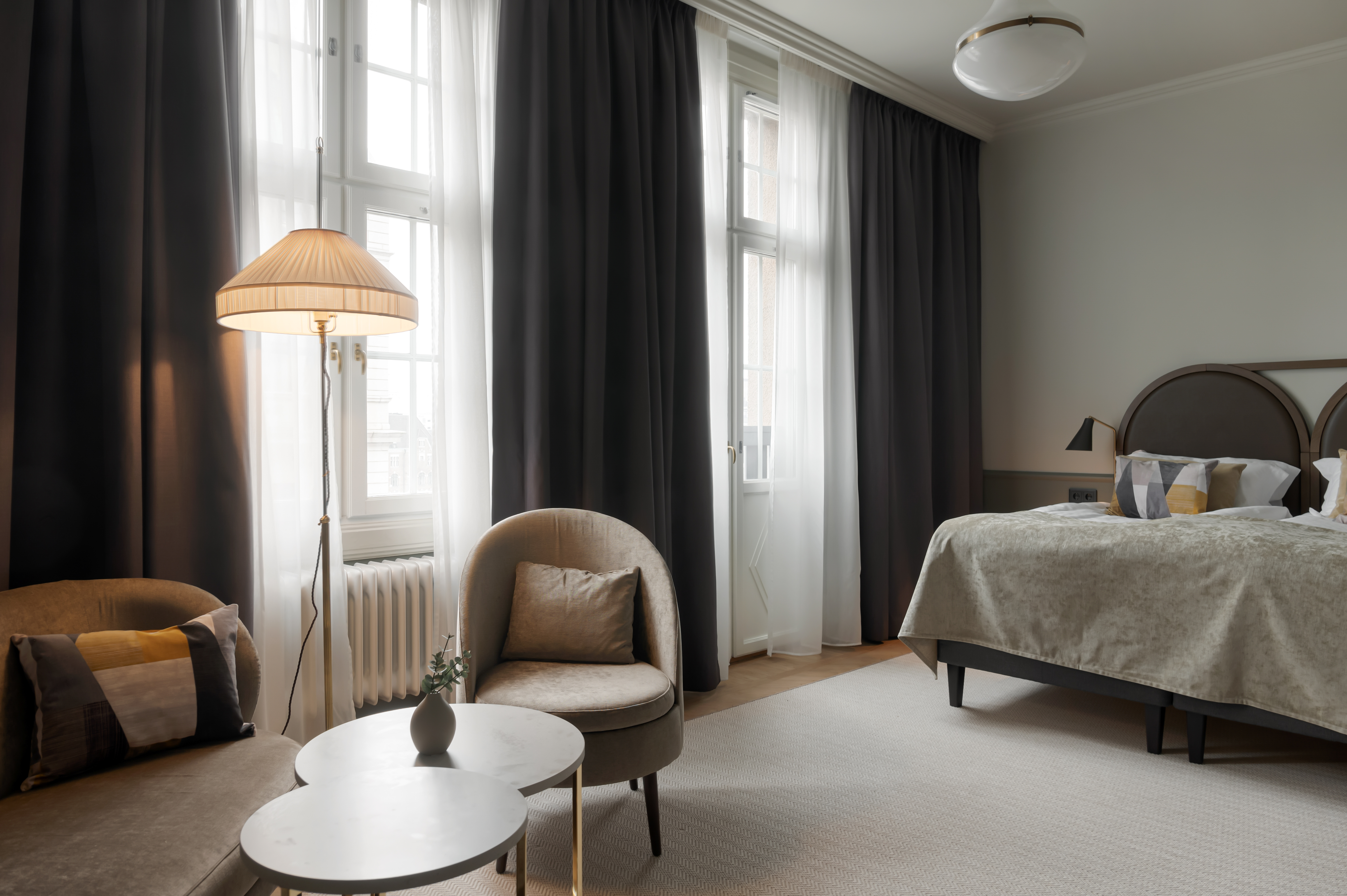 Hotel suite with cozy seating area and bed in the same room