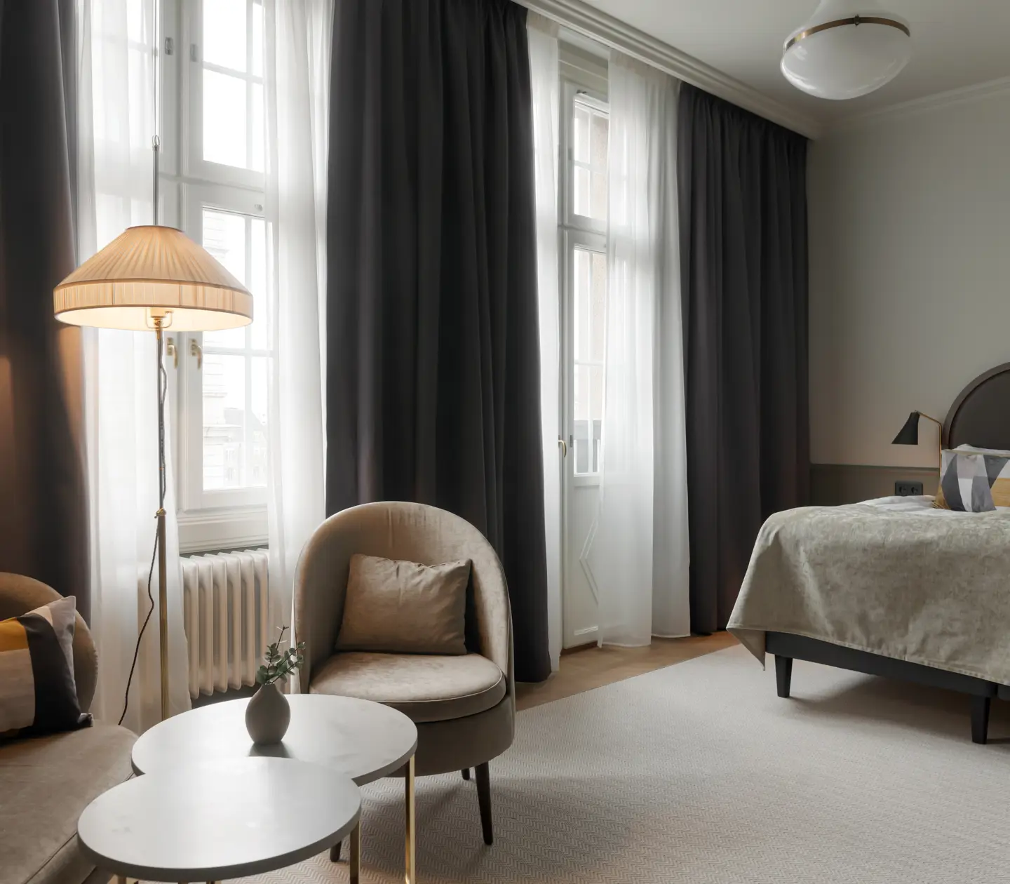 Hotel suite with cozy seating area and bed in the same room