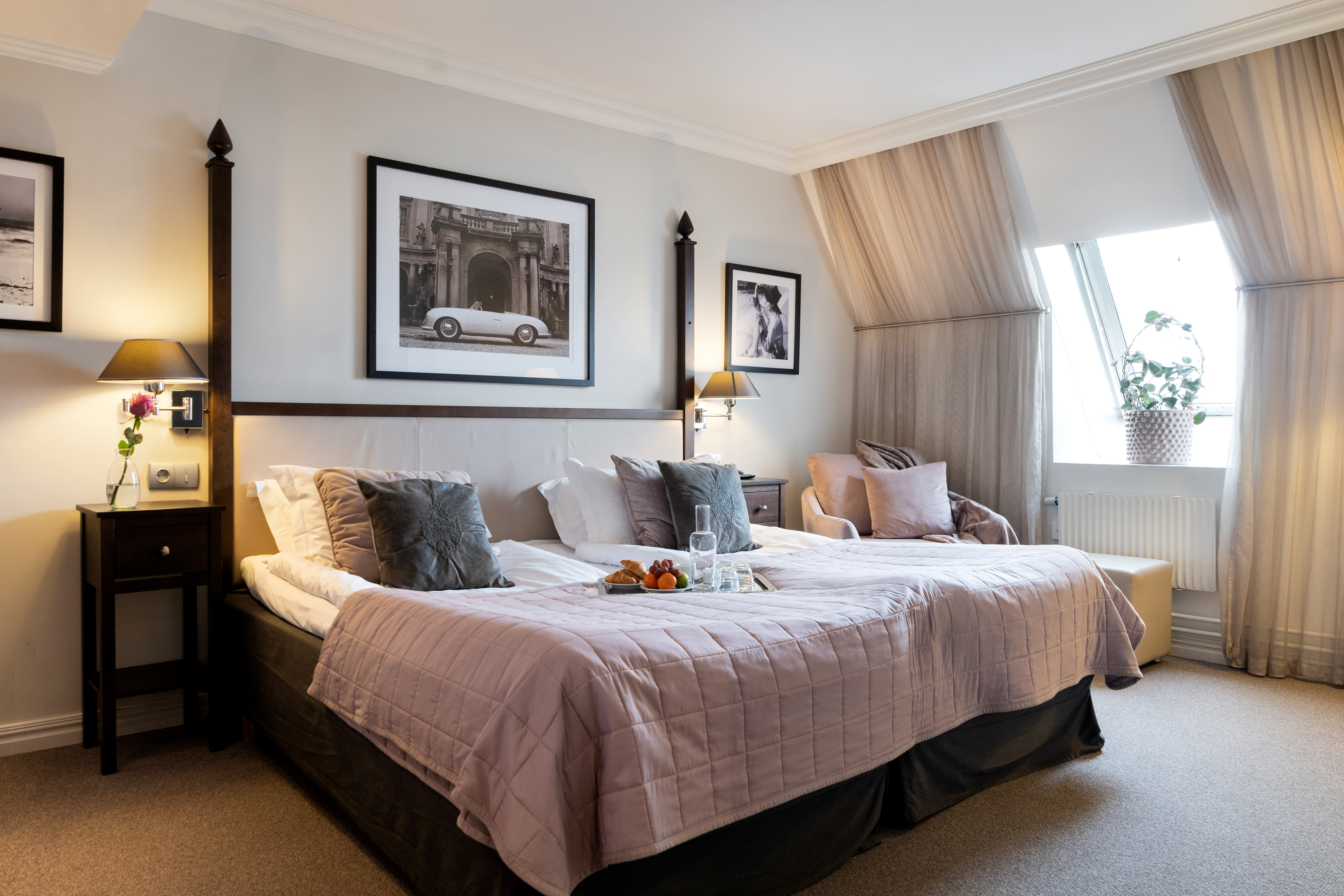 Hotellrum med blå soffgrupp och ett runt fönster intill