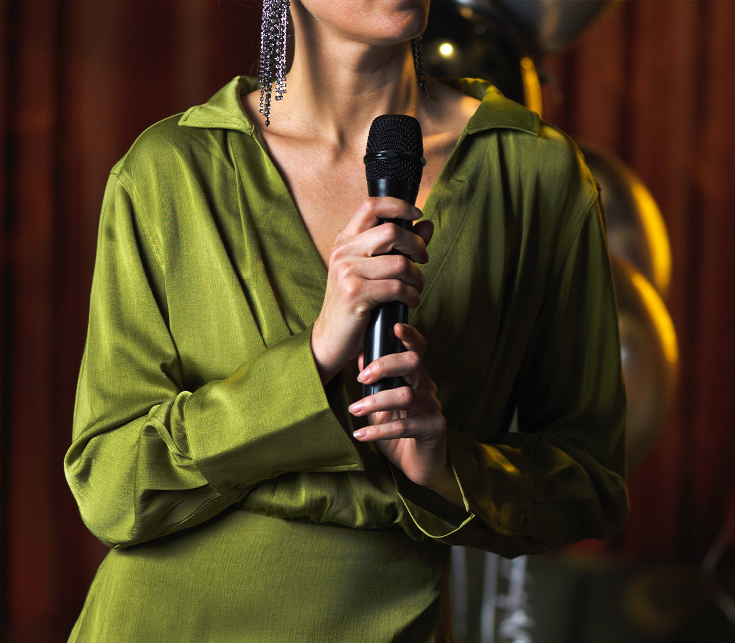 Woman in green dress is holding a microphone