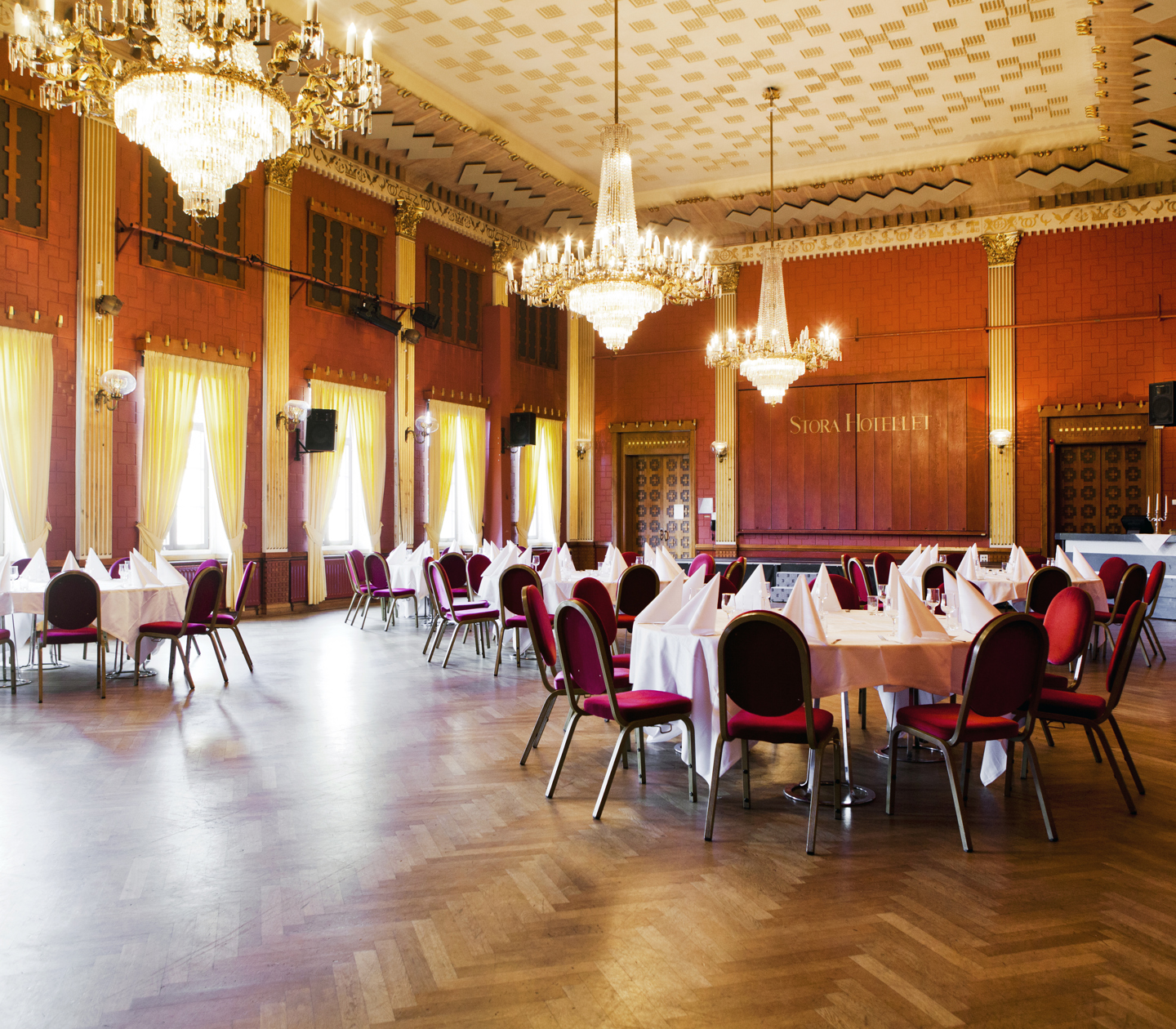 Pompous red hall with crystal chandeliers and round tables