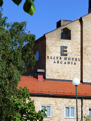 A large stone building with a facade sign that reads Elite Hotel Arcadia