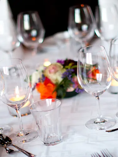 Table in wedding venue decorated with flowers and lit candles