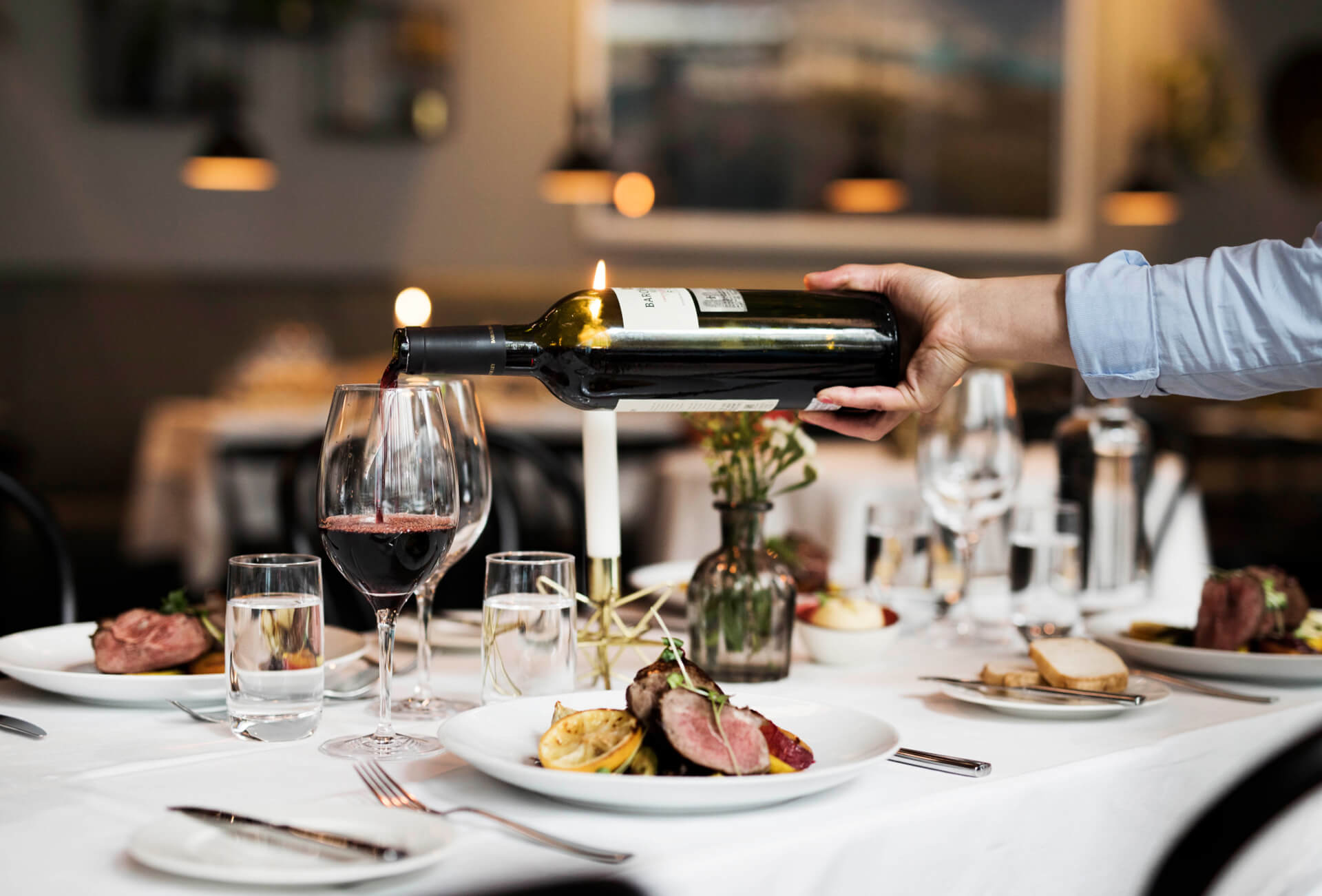 Servitör häller upp vin i glas på en restaurang