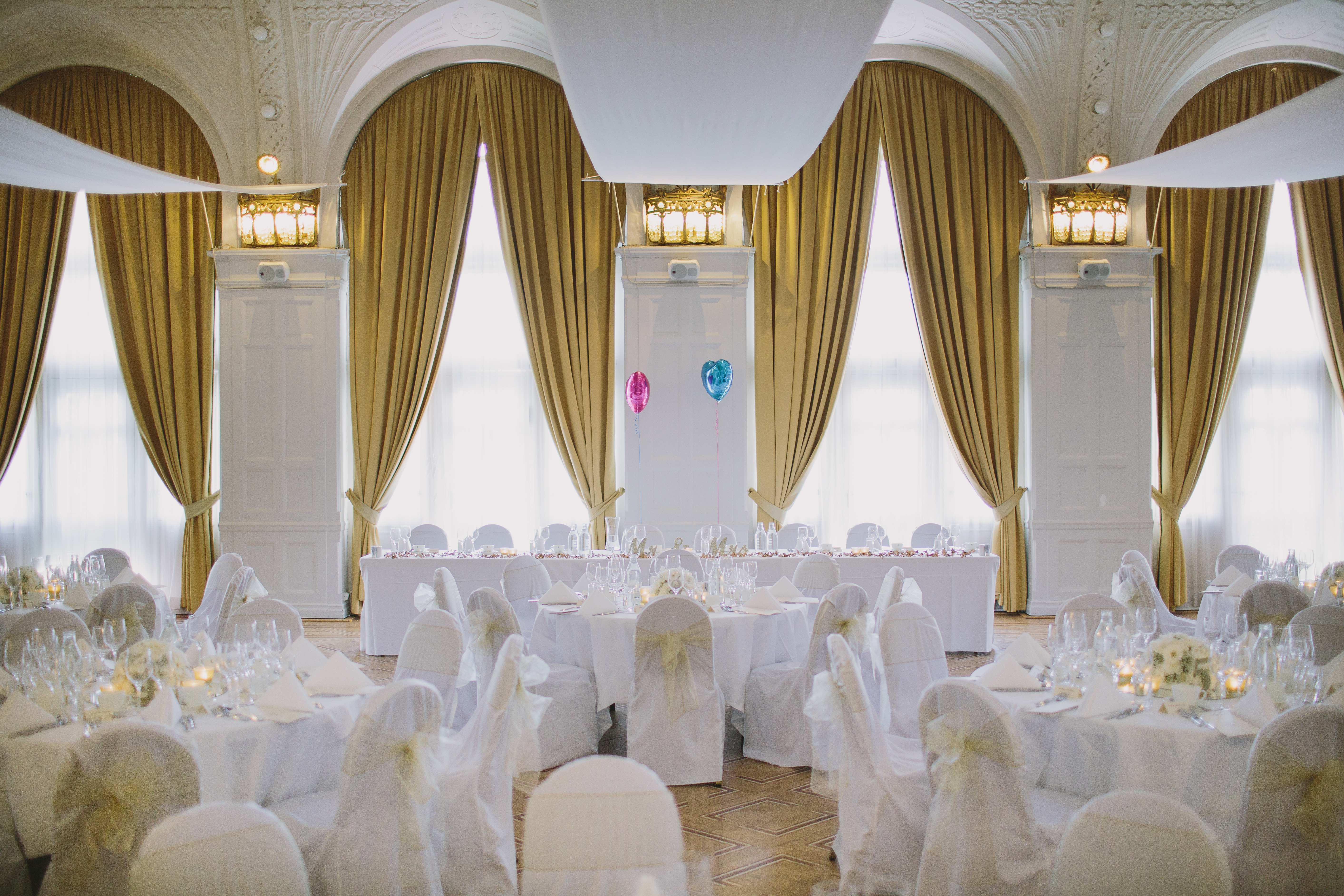 Gorgeous wedding venue with large windows and golden yellow curtains