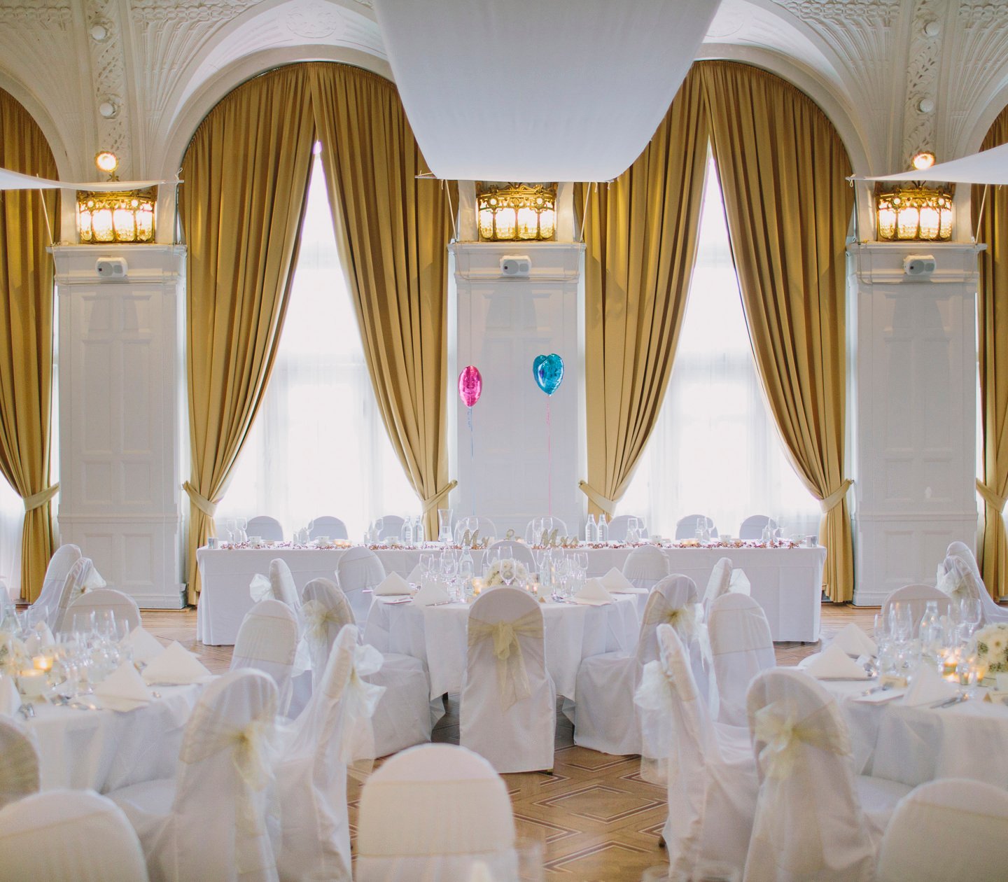 Gorgeous wedding venue with large windows and golden yellow curtains