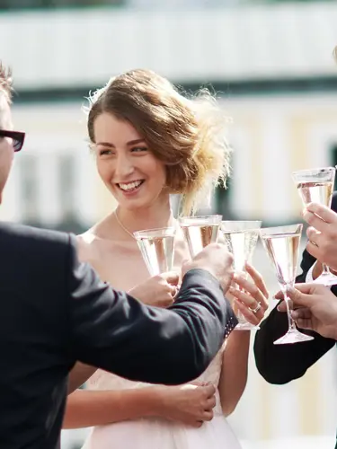 Well dressed people toast with champagne glasses