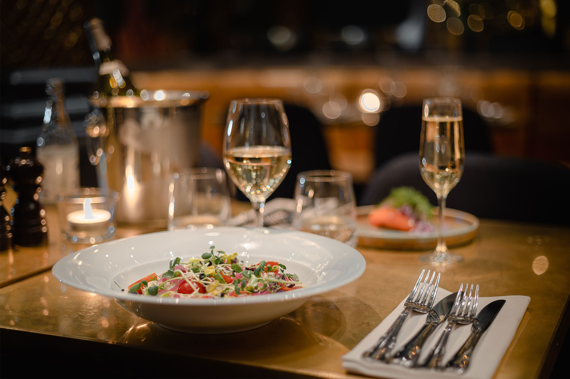 Middag uppdukad på bord med vinglas framför