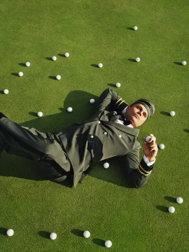 Woman with golf bag sitting in an armchair