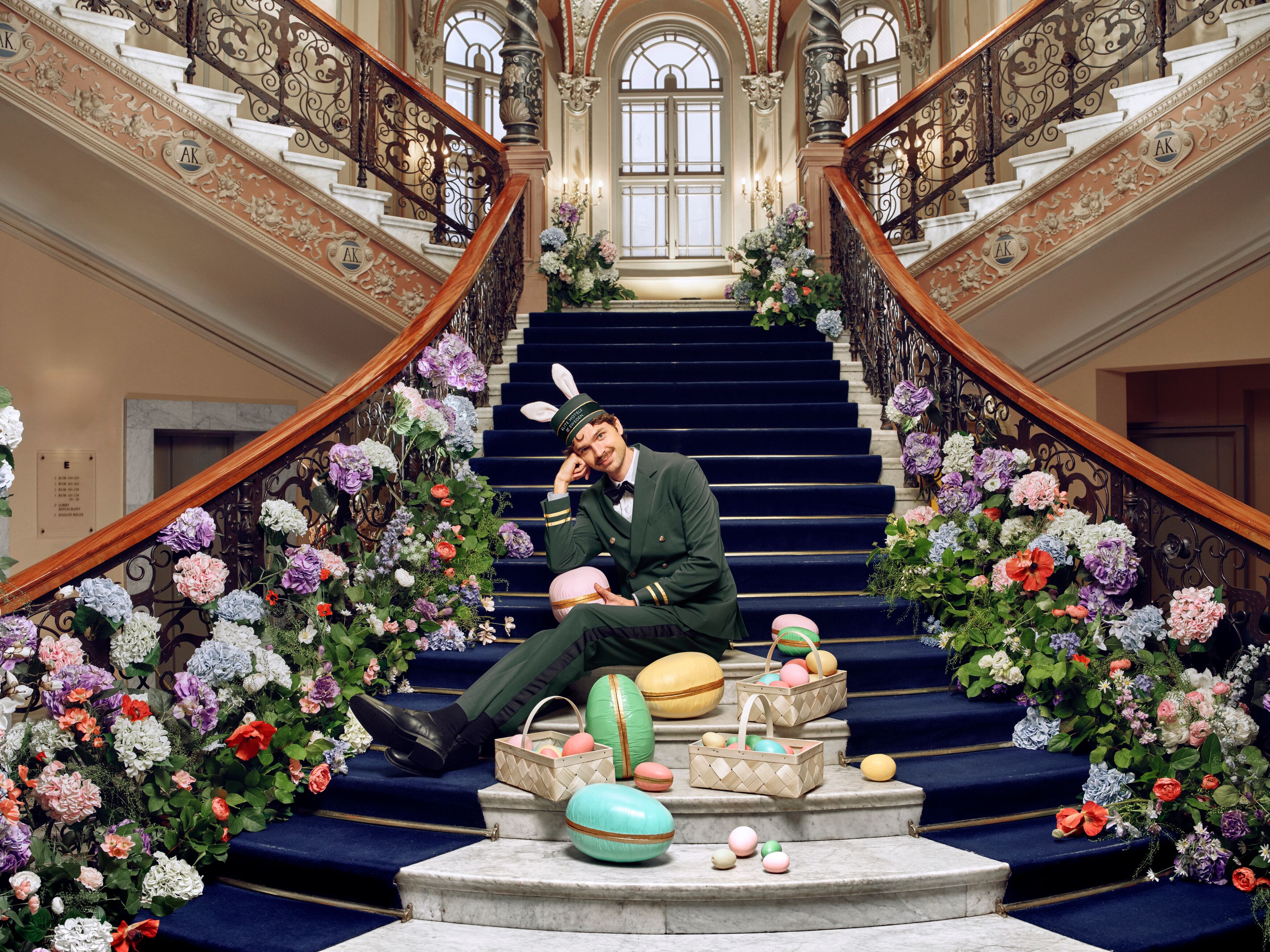 A bell boy sitting in stairs with Easter eggs