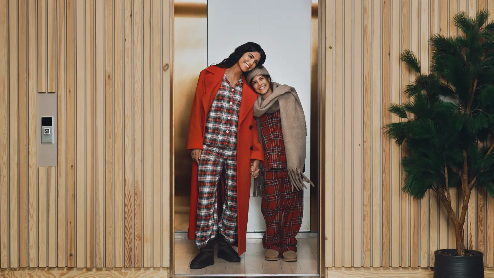 Kvinna framför fönster som håller isär gardiner