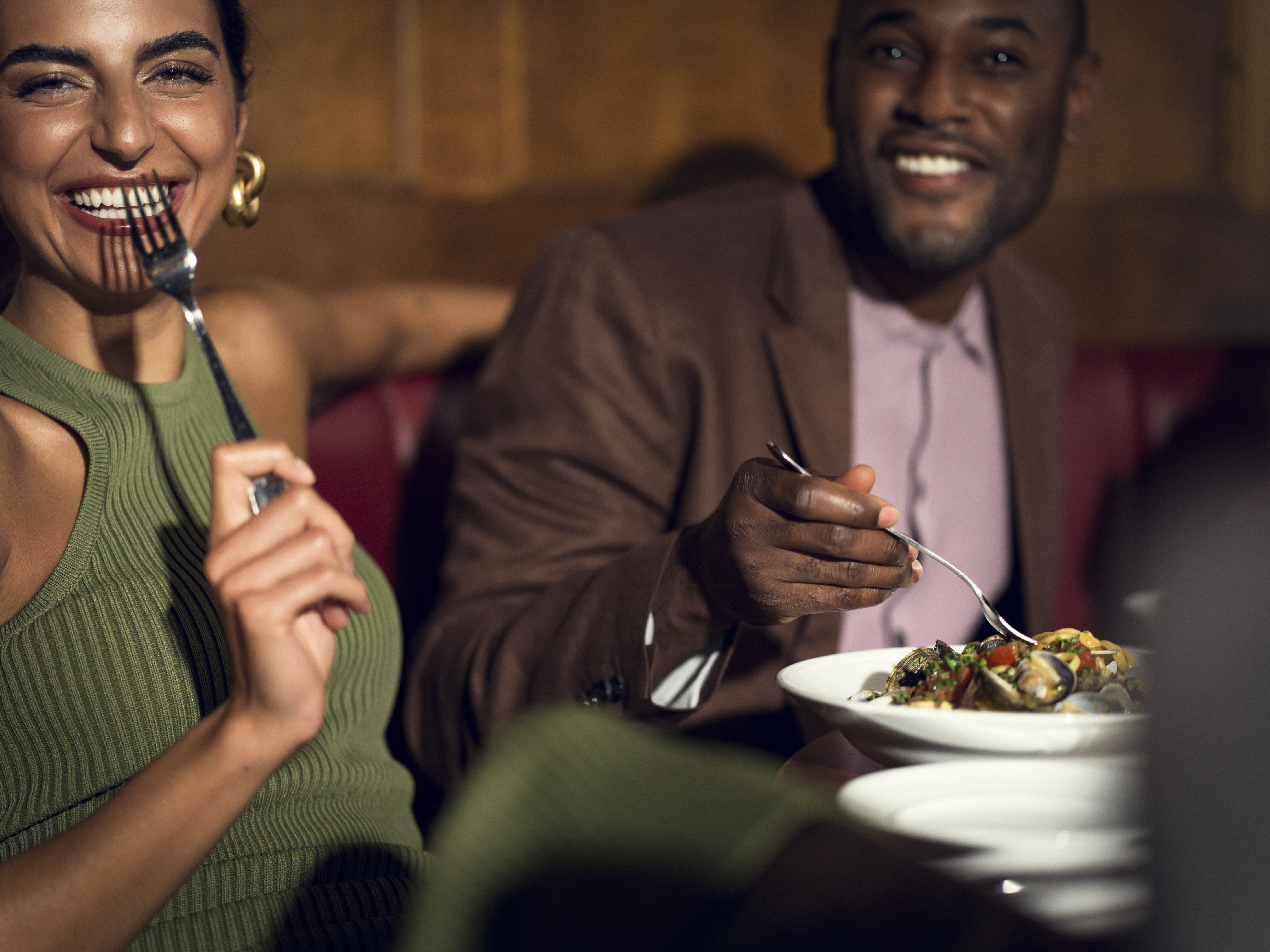 Man och kvinna som sitter vid bord och skrattar