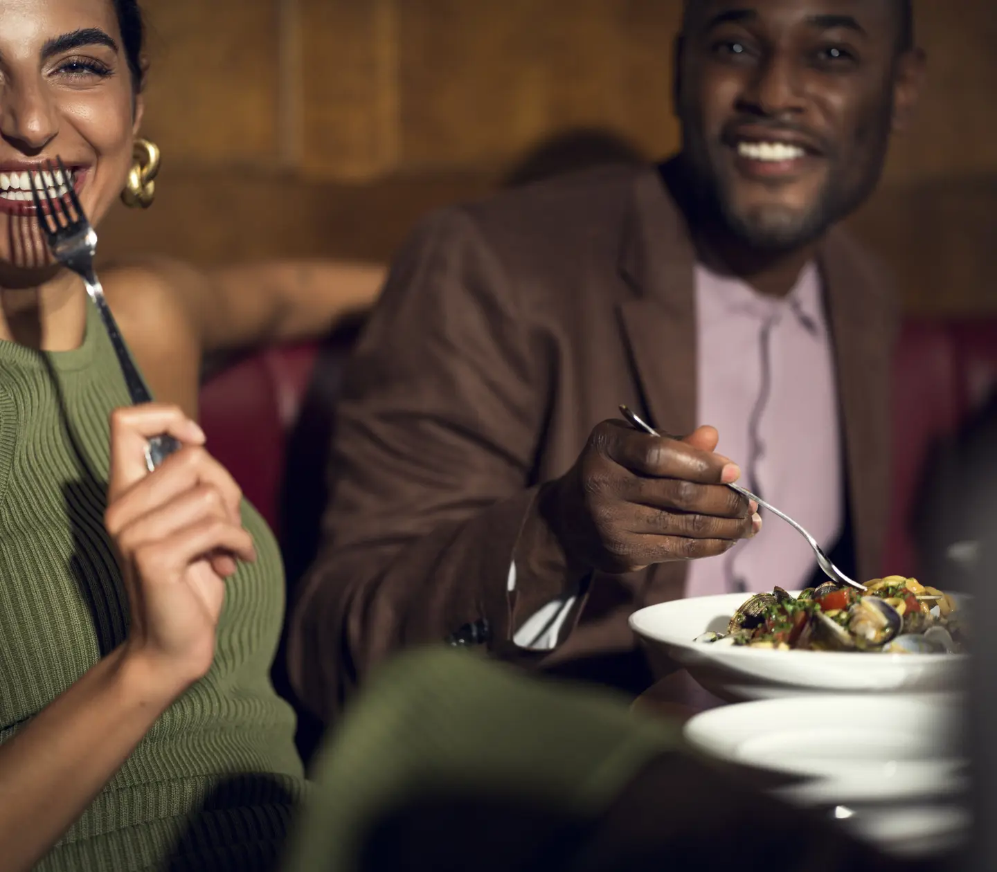 Man och kvinna som sitter vid bord och skrattar