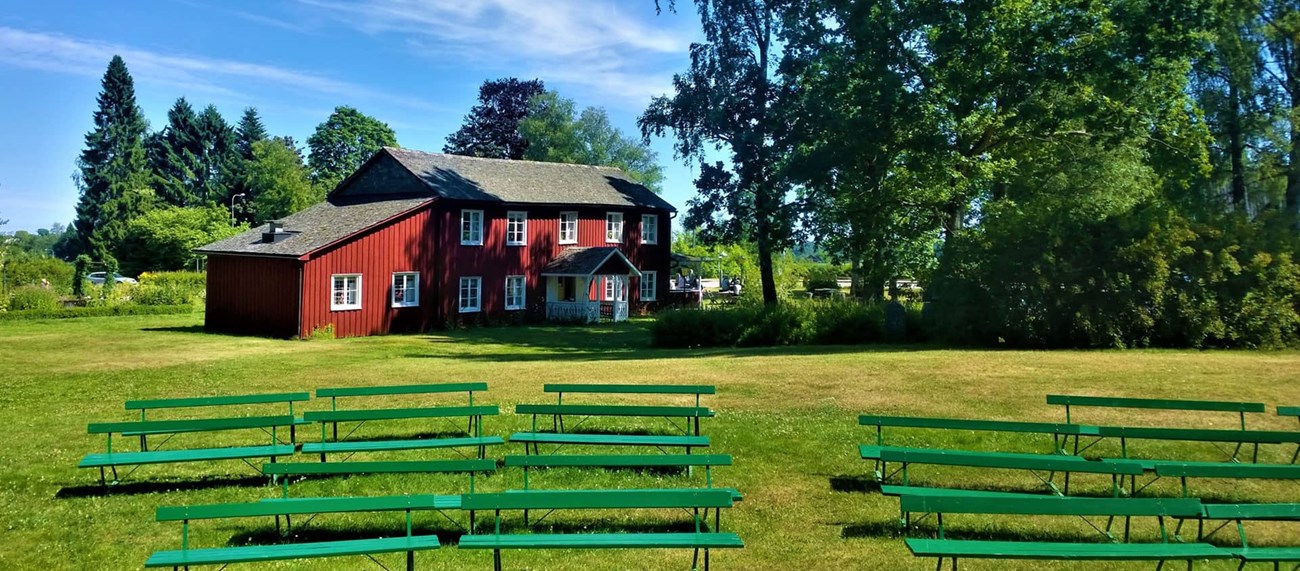 Svensk landsbygd, röd lada och gröna bänkar