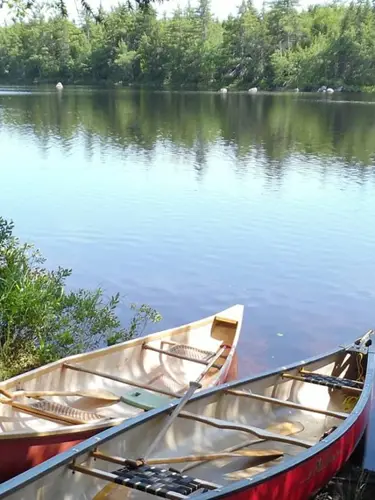 Kanoter vid strandkanten till sjö