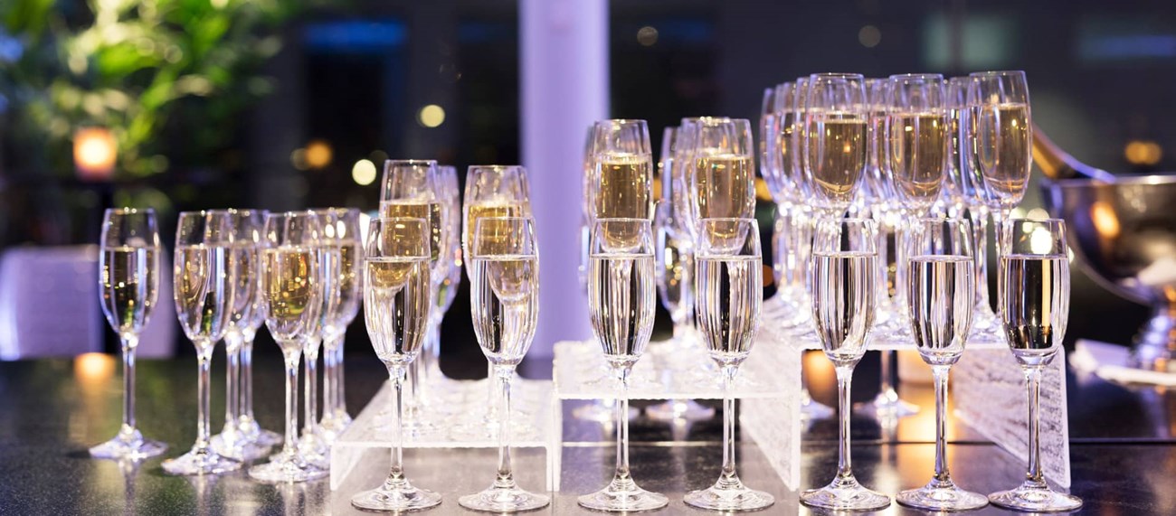 Flera champagneglas placerade i olika nivåer på ett bord. 