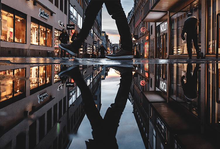 Blöta gator i Göteborgs stad som skapar häftiga reflektioner. 