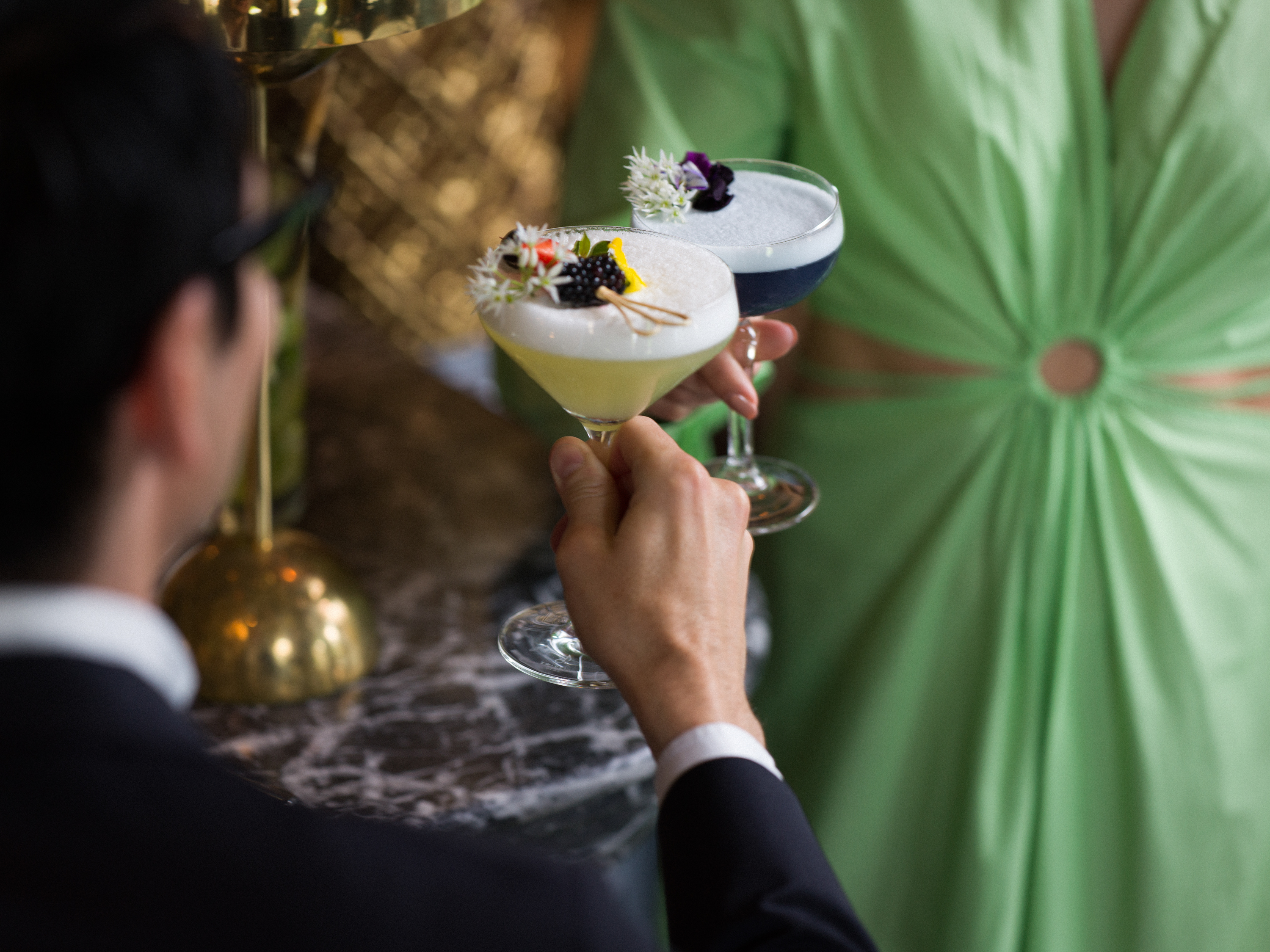 Par som skålar med festliga drinkar.