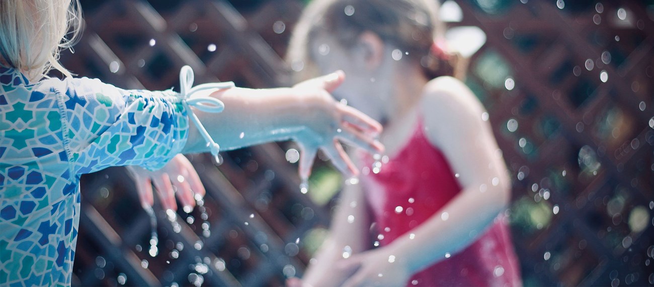 Två barn leker med vatten