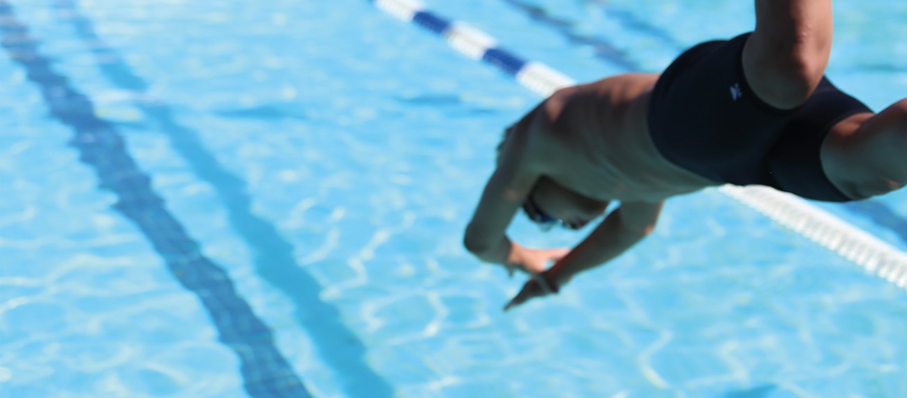 Ett barn som dyker ner i en pool