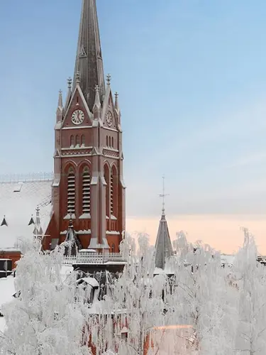 Snöigt stadslandskap med kyrka och blå himmel