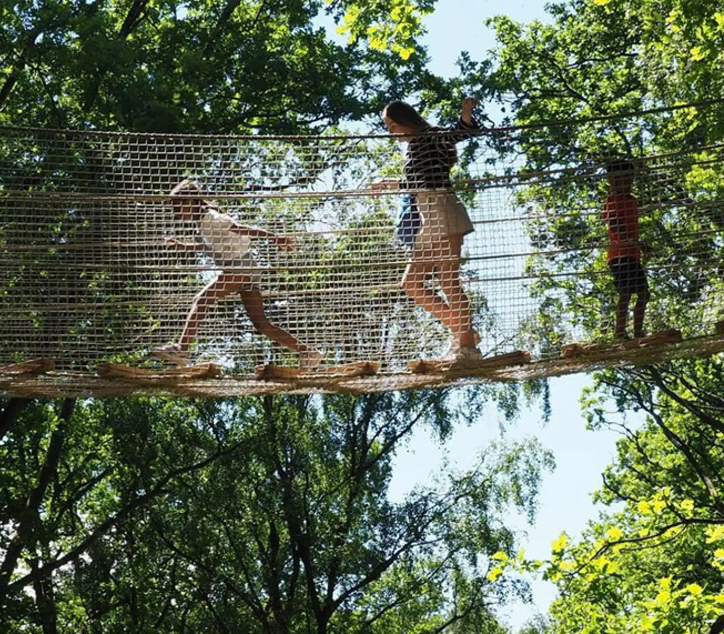 Barn går över en hängbro som finns på Skånes djurpark.