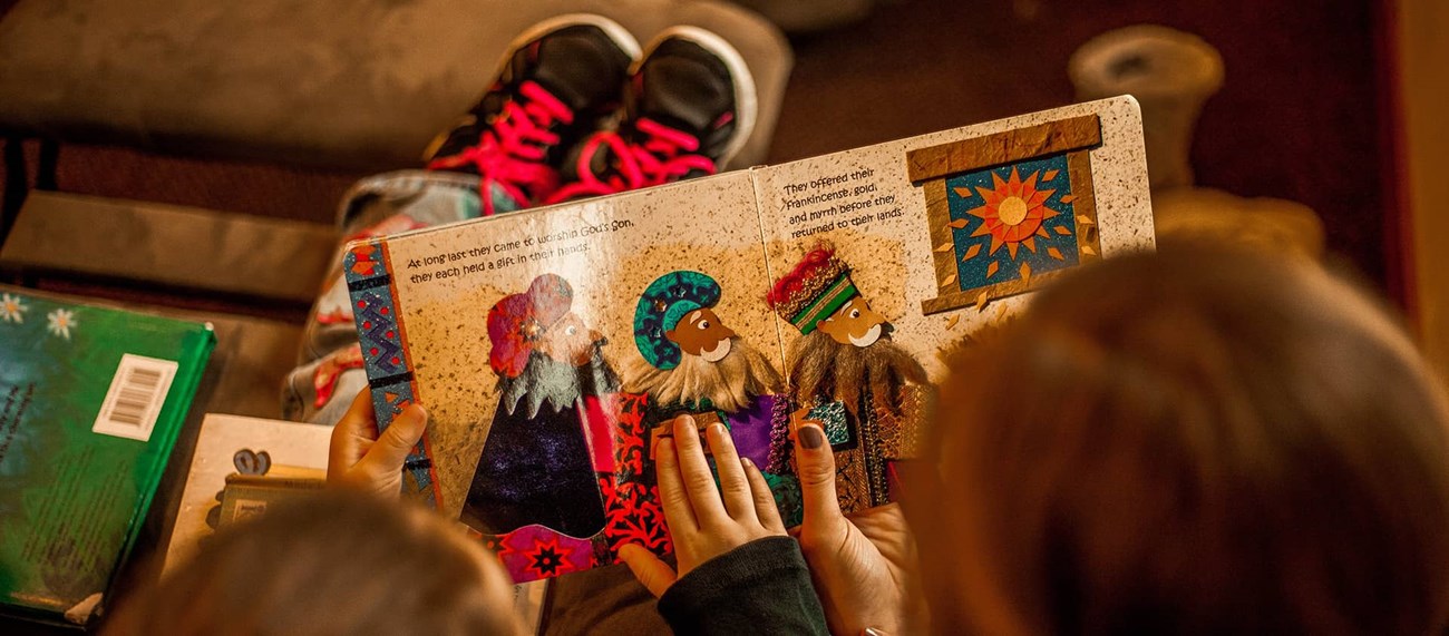 Närbild på två personer som läser en bok tillsammans
