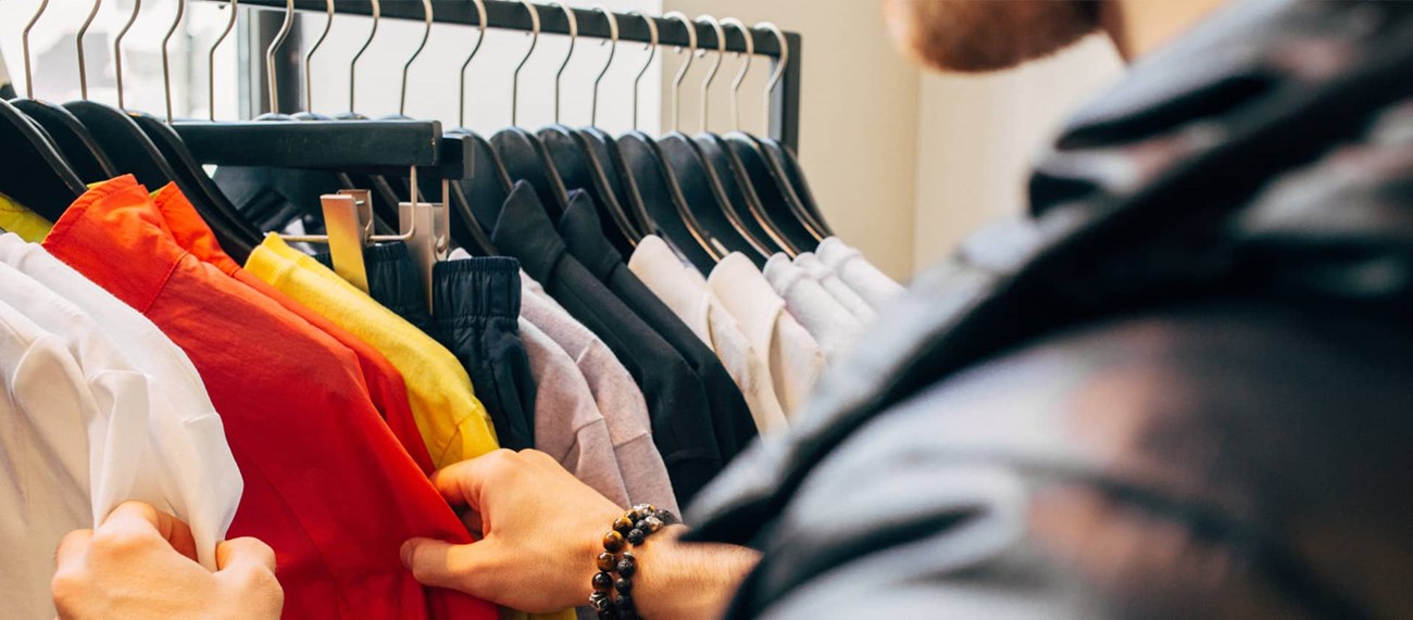 En person som tittar på skjortor i en butik