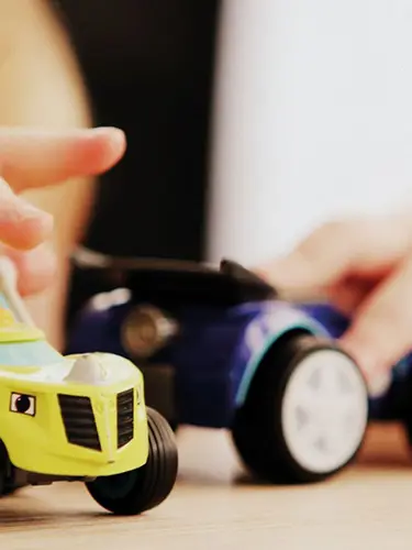 Ett barn leker med leksaksbilar