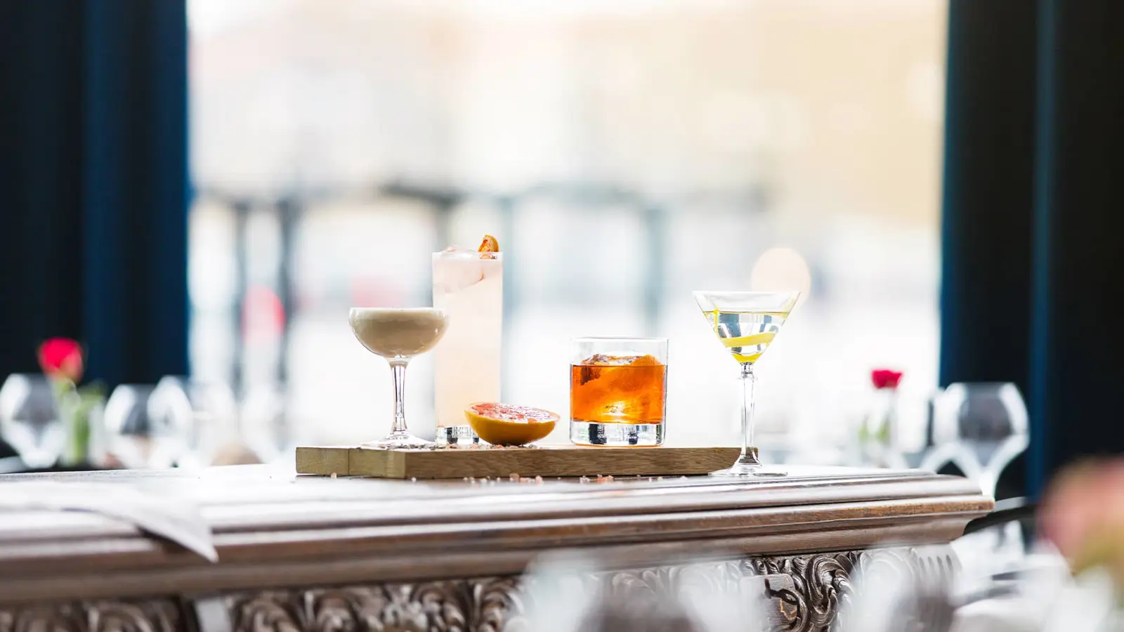 Various colorful drinks lined up on a tray in a bar
