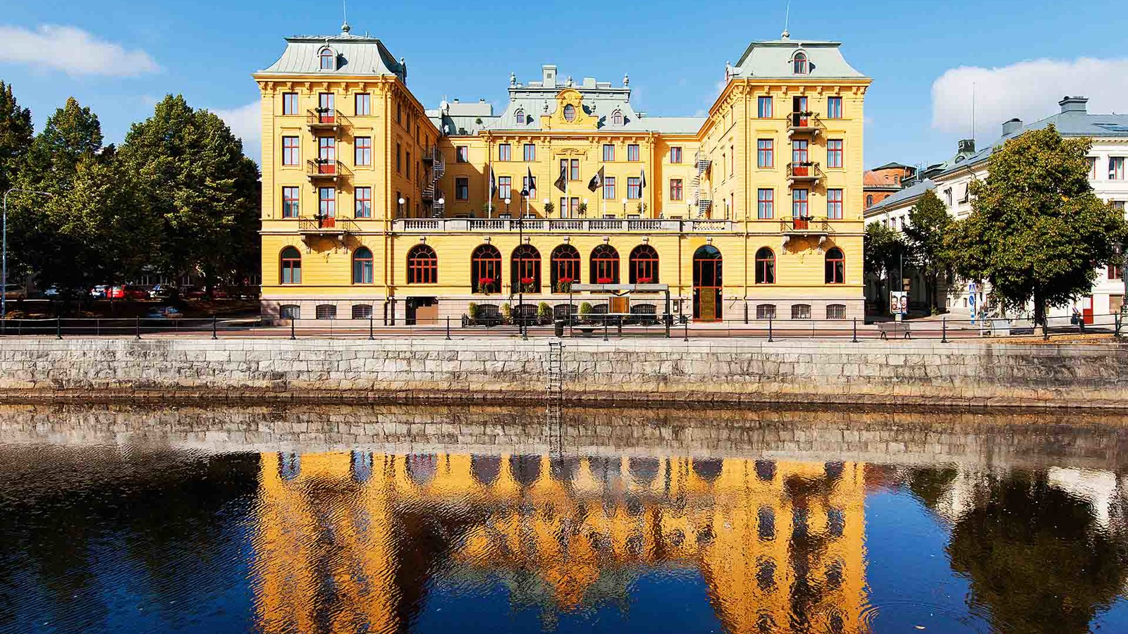 Elite Grand Hotel in Gävle's yellow facade with Gävleån flowing outside