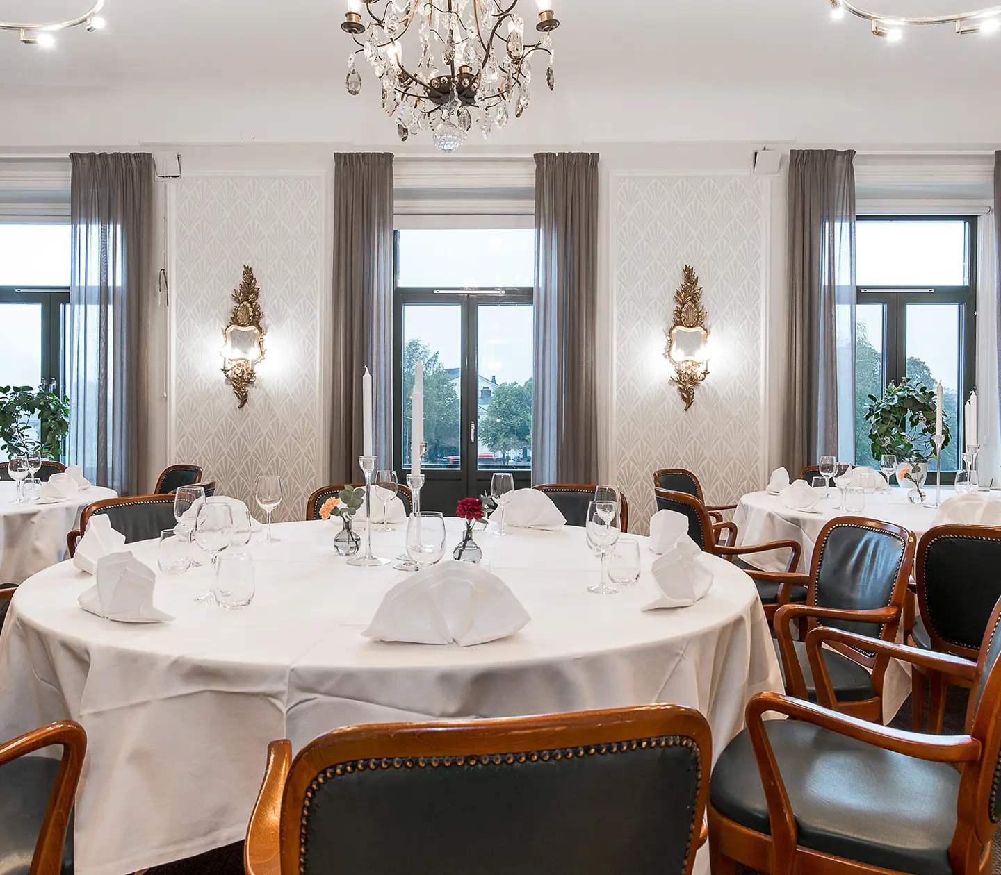 Ett fint konferensrum med tapeter, trästolar och blommor